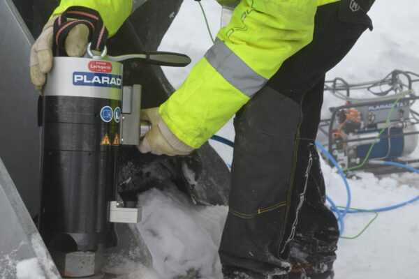 DSC_0166 A worker in a bright coat skillfully maneuvers the electrically operated TXE1docu and tensioner from Plarad, effortlessly handling snowy conditions.