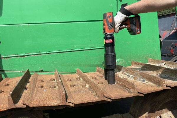 A person is tightening a bolt on a bulldozer using the Plarad DA2 Nutrunner/torque wrench.