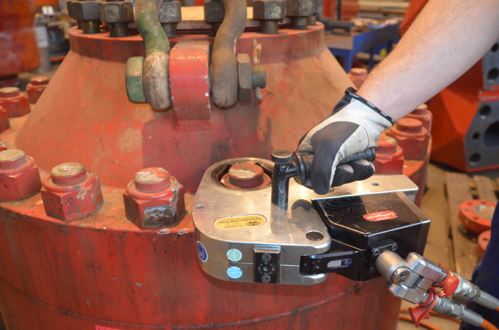 DSC_0132 A person is using a Plarad FSX flange torque wrench on a large red industrial valve.