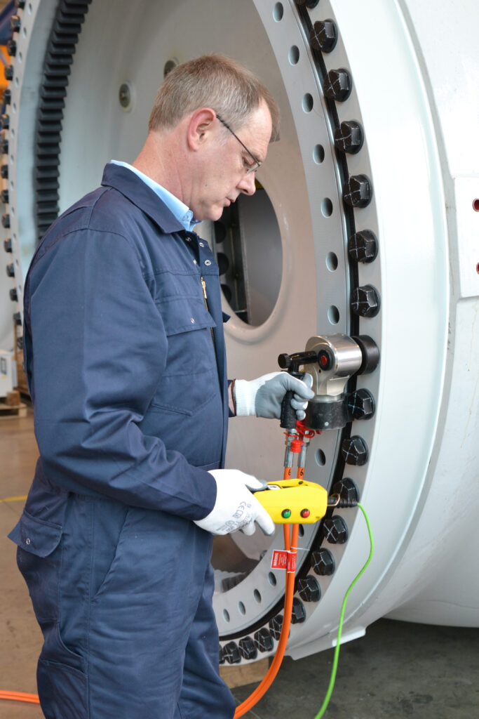 DSC_2429_bea A man in a blue overall operates a Plarad hydraulic square drive wrench on a large industrial bolt.