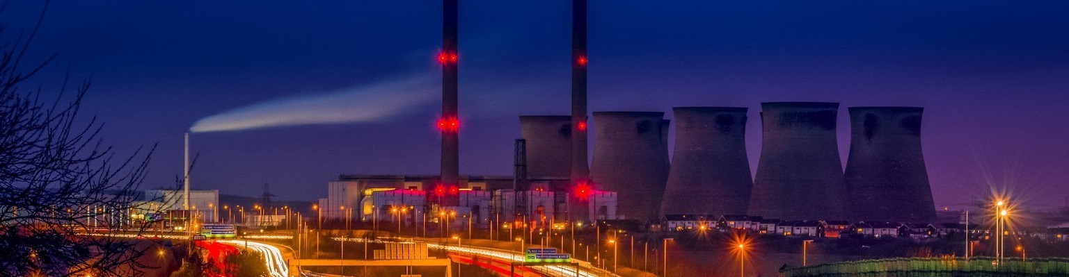 Eine Industrieanlage bei Nacht, mit ihren im Licht der Straßenlaternen und Lichtstreifen leuchtenden Schornsteinen und Kühltürmen, ist ein wahres Beispiel dafür, in jeder Branche zu Hause zu sein.