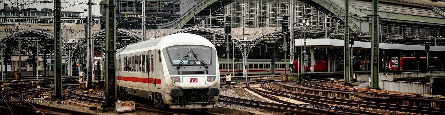 Zu sehen ist ein Zug und zahlreiche Bahngleise.