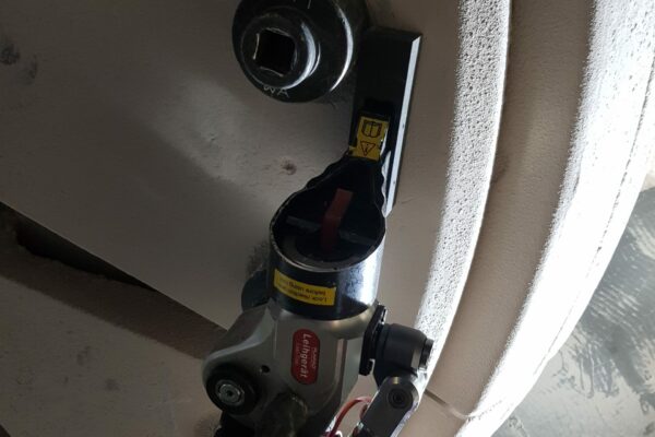 20190425_095521 A hydraulic square drive wrench from Plarad is a mechanical tool that is carefully attached to bolts and various components on a large metal surface, ensuring reliability and precision.