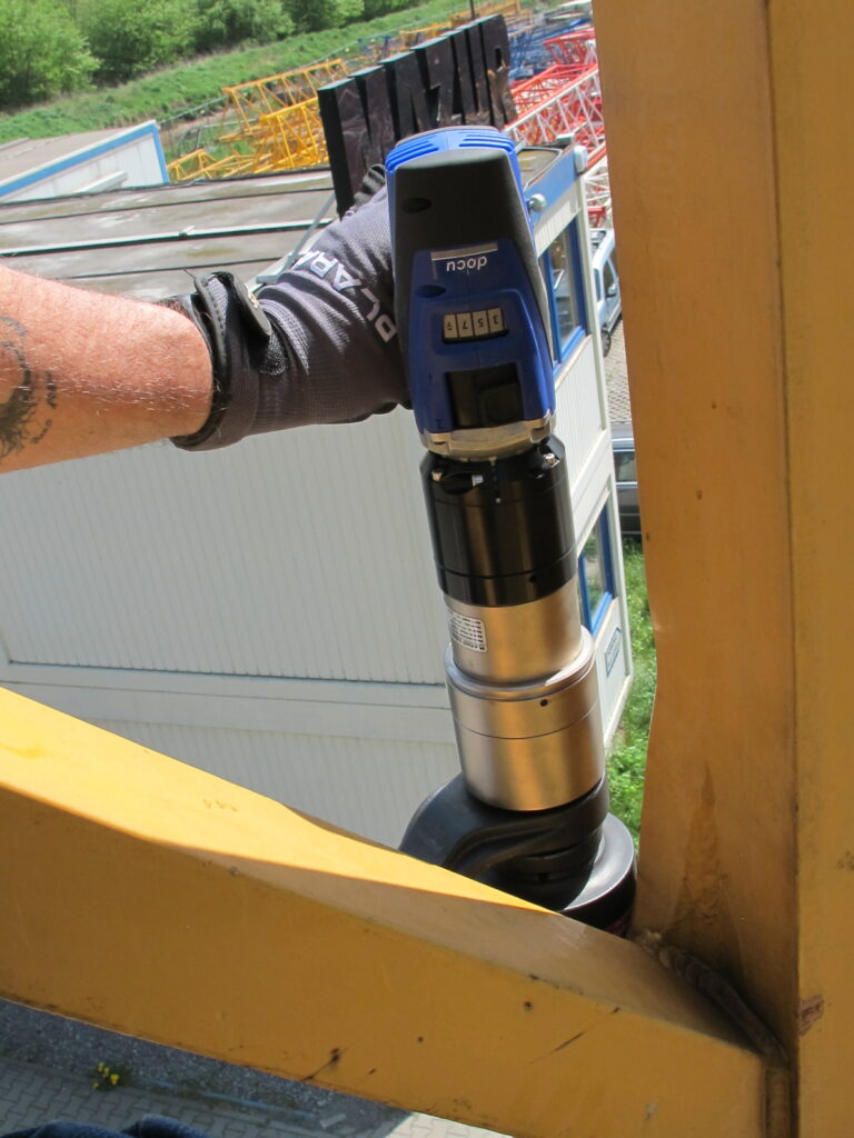 IMG_1966 A worker expertly uses the battery-powered torque wrench and bolting technology from PLARAD 🔧 on a metal structure outdoors, ensuring precision and efficiency with every turn.