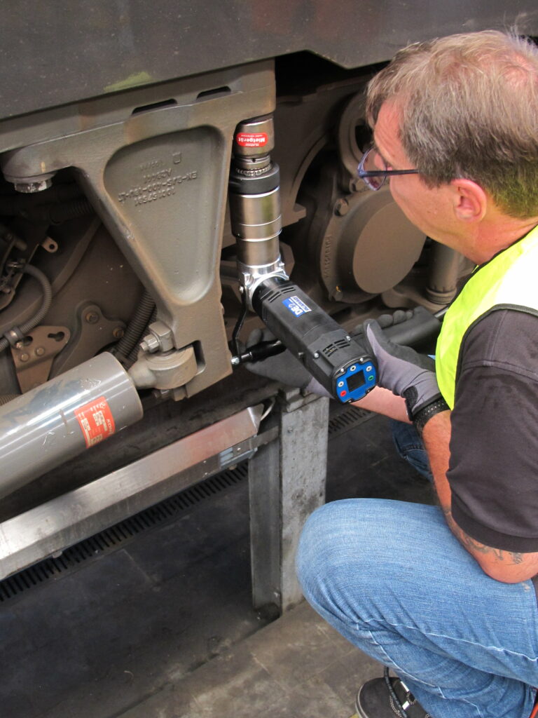 IMG_2042 A man is using the DE1 electronic nutrunner from Plarad on an industrial machinery component.