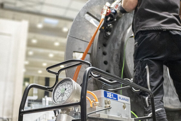 Arbeiter mit hydraulischem Drehmomentwerkzeug und Plarad XE1 Pumpe