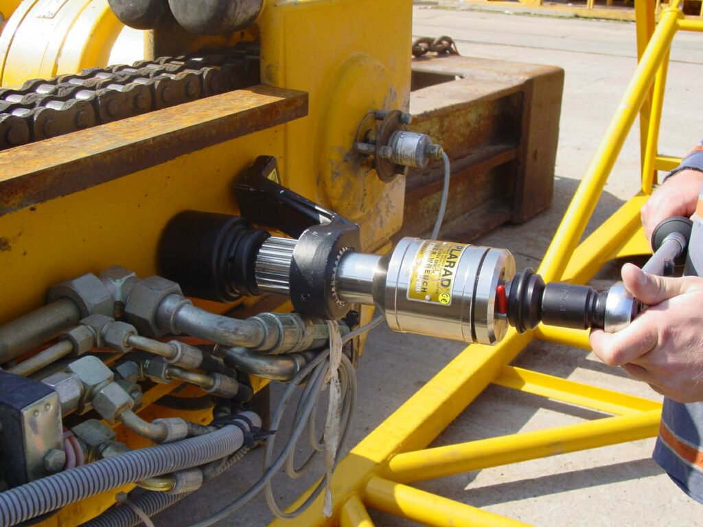 DSC01204 Plarad Power Wrench zur Verschraubung an einem großen gelben Industriemaschinentei