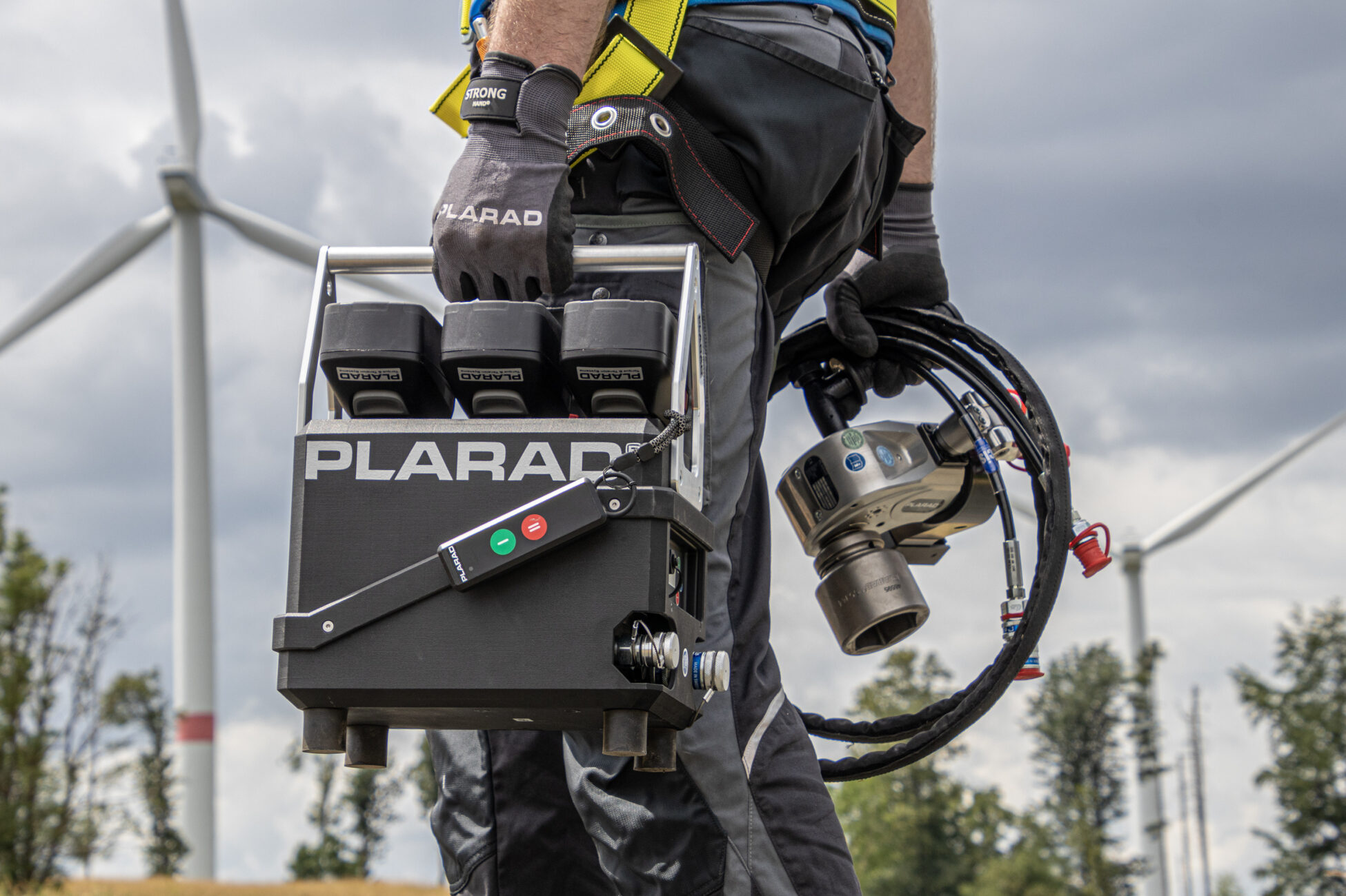 Arbeiter mit Plarad Hydraulikpumpe und Drehmomentschrauber von Plarad im Freien.
