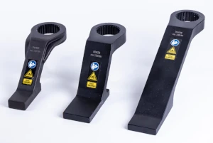 Three black hydraulic torque wrench hex drives of varying sizes on a white background, featuring warning labels—optimal accessories for products by Plarad to perfect the bolting result.
