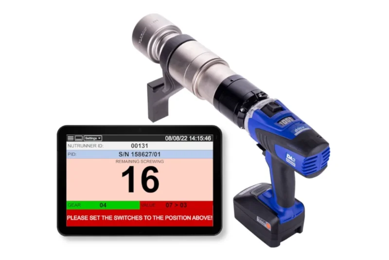 A cordless Drehmomentschrauber Made in Germany sits next to a digital screen displaying torque data and instructions.